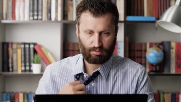 Heat, excitement, deadline, nervous tension concept. Sweating man in wet shirt and plain look works at computer, he is hotly muffled and uncomfortable, drinks water and pours it on himself. Close-up — Stock Video