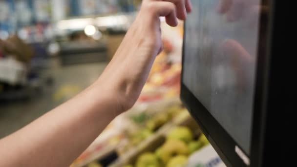 Vrouwelijke hand drukt op knoppen van weegschalen in supermarkt — Stockvideo