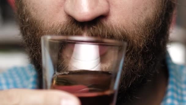 A szakállas ember whiskyt iszik. A férfi kéz üveget hoz a szájába és whiskyt iszik. — Stock videók