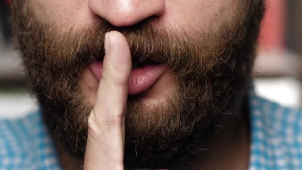 Bearded man asks for silence. Guy brings index finger to her lips and makes gesture calling for silence — Stock Video