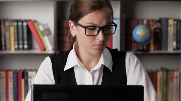 Een vrouw die op de computer werkt. Gericht aantrekkelijk meisje in bril werknemer freelancer zakenman verkoper op de werkplek typen op laptop toetsenbord voert gegevens en het drinken van koffie of thee. Close-up — Stockvideo