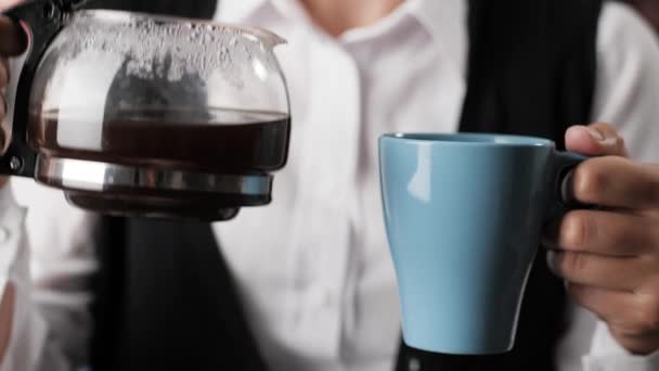 Woman pours coffee. Female hand pours coffee from coffee maker into blue mug. Close-up — Stock Video