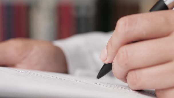 Documenten voor ondertekening. Vrouwelijke hand zet handtekening op wit vel papier. Voltooiing van de transactie, ondertekening van het contract, papierwerk concept. Close-up — Stockvideo