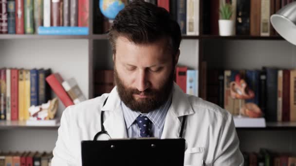 Doktor usne na pracovišti. Velmi unavený nebo bezesný lékař na pracovišti si čte lékařskou kartu a usne, hlava mu klesne na prsa a na krátkou dobu ztratí vědomí — Stock video