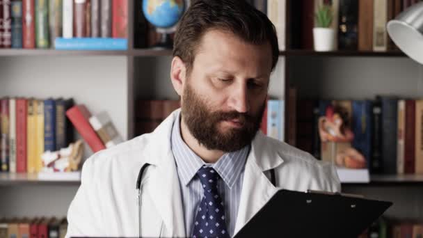 Lekarz podpisuje dokumenty. Poważny, skupiony lekarz w białym płaszczu w biurze szpitalnym, przynoszą mu dokumenty, podpisuje je i oddaje. — Wideo stockowe