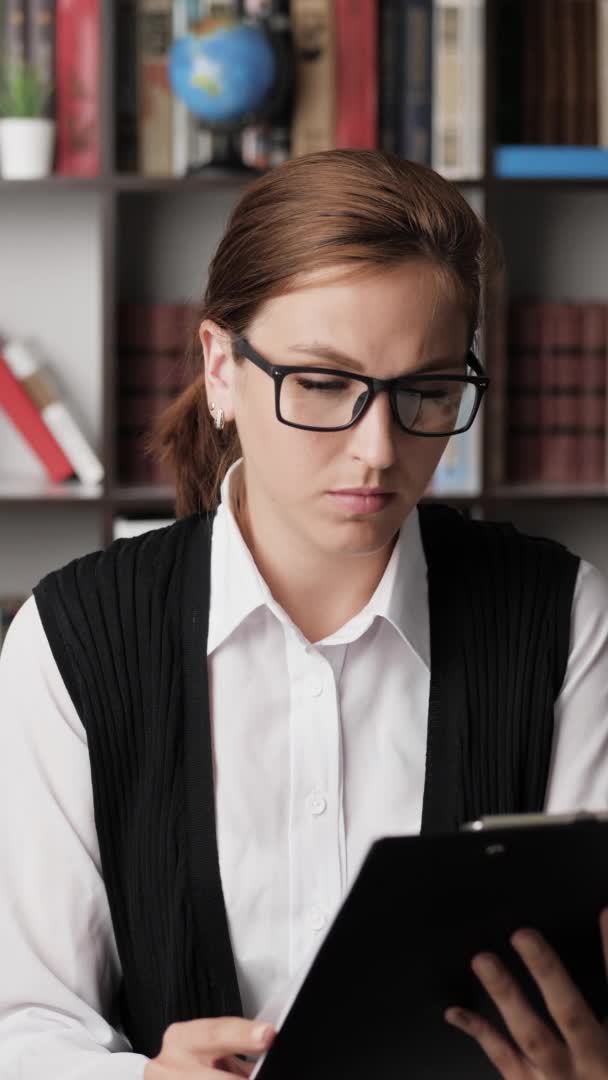 Vertikální pohled zaměřený žena pracovník na volné noze obchodník s brýlemi pečlivě čte dokumenty, otočí stránku. Detailní záběr — Stock video