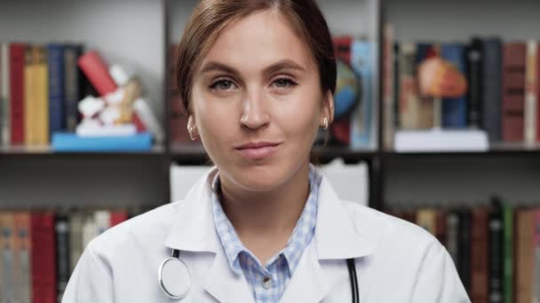 Dokter duim omhoog. Vriendelijke vrouwelijke arts in witte jas en stethoscoop in kantoor kijkt naar de camera en steekt haar hand op, toont duim omhoog, knikt en glimlacht goedkeurend — Stockvideo