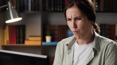 Diş ağrısı. Akşamları iş yerindeki çekici kadın dizüstü bilgisayarda çalışıyor ve diş ağrısı çekiyor, parmaklarıyla yüzüne dokunuyor ve acıyı hafifletmeye çalışıyor. Caries, pulpitis, sakız problemleri konsepti