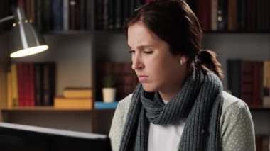 Öksürük, hapşırma, akan burun. Akşamları iş yerinde çalışan bir kadın laptopta öksürüyor ve burnunu peçeteyle siliyor. Grip, grip, alerji, koronavirüs, covid-19 konsepti.