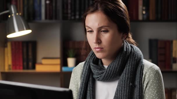 Kvinna arbetar på laptop typer text på tangentbordet på arbetsplatsen på kvällen, matar in data och svar telefon — Stockvideo