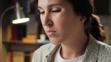 Boyun ağrısı. Geceleri boynu ağrıyan yorgun bir kadının yüzü ve kaslarını esnetmeye çalışan eliyle ona dokunuyor. Servikal osteokondrosis, yorgunluk konsepti. Yakın plan.