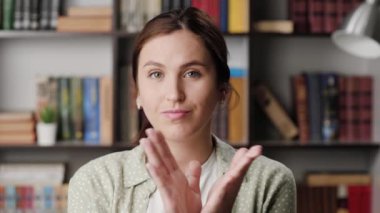 Kadın alaycı alkışları. Ofisteki ya da dairedeki kasvetli şüpheci kadın kameraya bakar ve sahte alkış yaratmak için isteksizce avuçlarını çırpar.