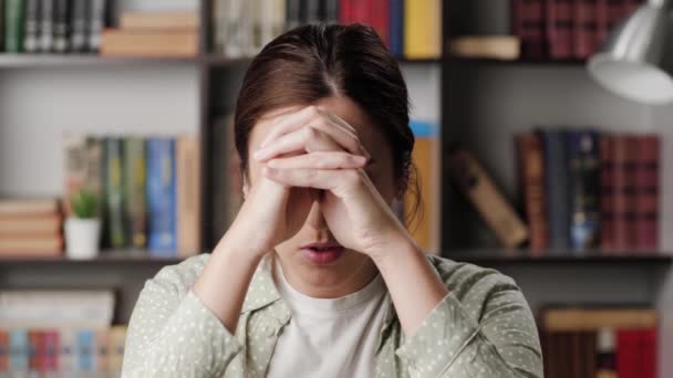 女人祈祷。在办公室或公寓里的悲伤女人看着摄像机，她仰着头，把手放在头上，开始祈祷，说着各种各样的话 — 图库视频影像