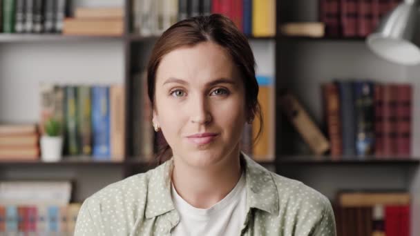 La mujer está bien. Mujer sonriente positiva en la oficina o habitación del apartamento mirando a la cámara y con gesto su mano derecha mostrando signo OK — Vídeos de Stock