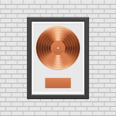 Beyaz tuğla duvarda siyah çerçeveli bronz plak.