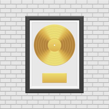 Beyaz tuğla duvarda siyah çerçeveli altın plak.