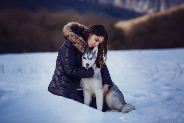 美しい景色を眺めながら山の中にいるシベリアのハスキー犬を持つ女性ハイカー — ストック写真