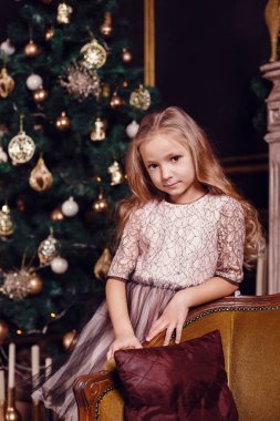 Mumlar ve hediyelerle köknar ağacı ve şömine önünde rahibeler. Yeni yıl arifesi. Noel arifesi. Köknar ağacında sıcak bir tatil Işıklar ve altın dekor ile.