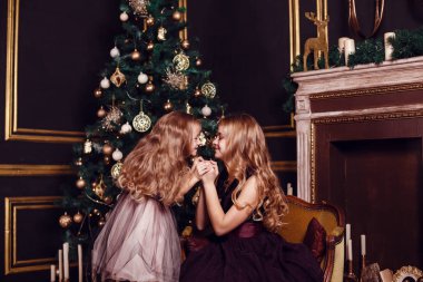 Mumlar ve hediyelerle köknar ağacı ve şömine önünde rahibeler. Yeni yıl arifesi. Noel arifesi. Köknar ağacında sıcak bir tatil Işıklar ve altın dekor ile.