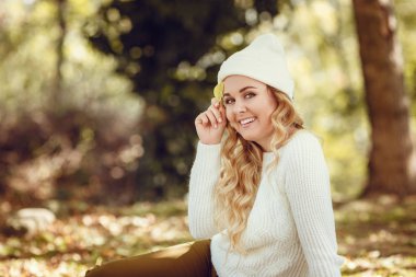 Sonbaharda parkta duran zarif bir kadın.