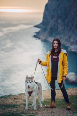 Genç bayan Sibirya köpeğiyle dağlarda oturuyor.