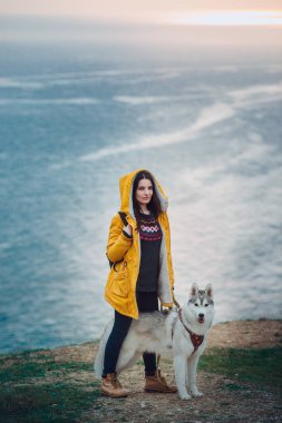 Genç bayan Sibirya köpeğiyle dağlarda oturuyor.
