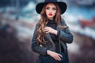 Bir siyah şapka ve gri ceket, siyah elbise giymiş, evning şehirde poz genç güzel kız mükemmel makyaj, kırmızı dudaklar,.