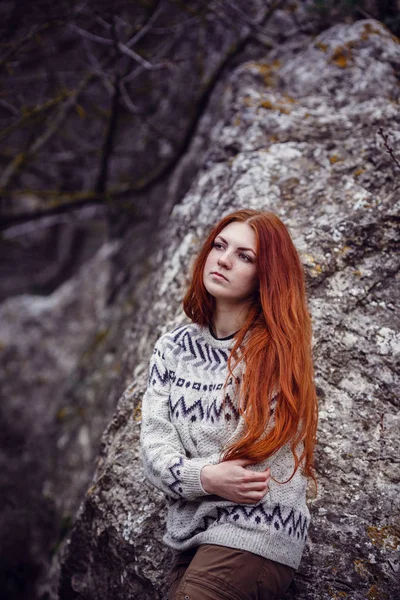beautiful redhead young woman with freckles enjoying the beauty of nature walking by the sea