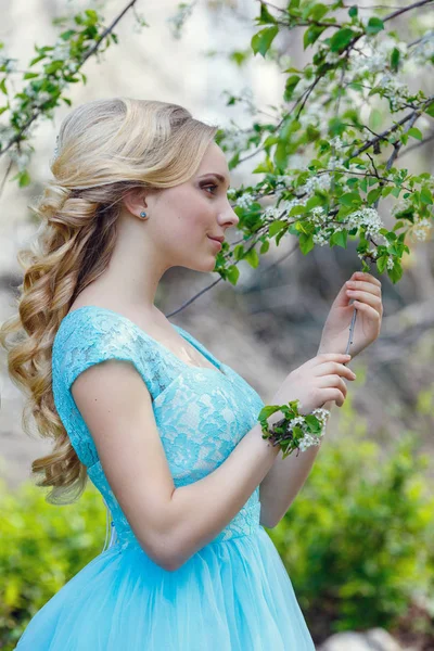 Mooie blonde jonge vrouw die het dragen van modieuze kleding, wandelen in het park voorjaarsbijeenkomst. — Stockfoto