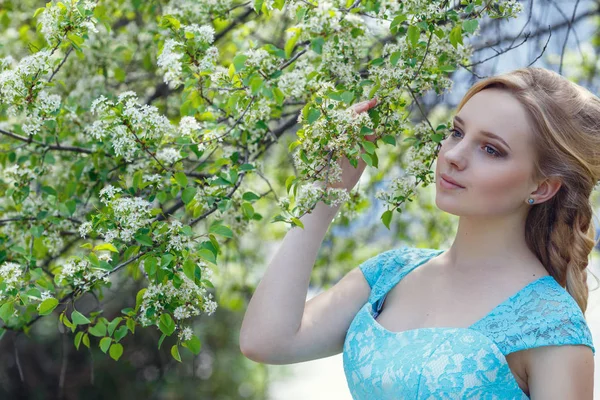 Mooie blonde jonge vrouw die het dragen van modieuze kleding, wandelen in het park voorjaarsbijeenkomst. — Stockfoto