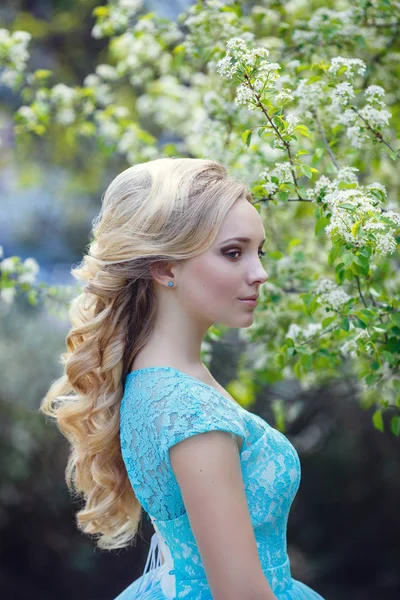 Mooie blonde jonge vrouw die het dragen van modieuze kleding, wandelen in het park voorjaarsbijeenkomst. — Stockfoto