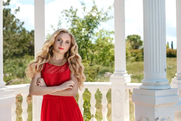 Porträt eines stilvollen schönen Mädchens, das ein kurzes rotes Kleid trägt oder auf der Straße posiert — Stockfoto