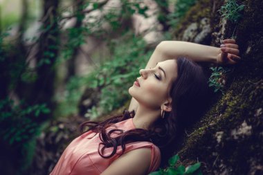 Nehir cadı. Pembe uzun elbise, muhteşem bir görüntü. Moda tonlama. Yaratıcı renk. Nehrin yanında mistik bir ormandaki güzel dansçı