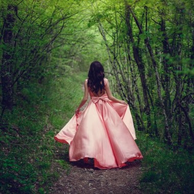 Nehir cadı. Pembe uzun elbise, muhteşem bir görüntü. Moda tonlama. Yaratıcı renk. Nehrin yanında mistik bir ormandaki güzel dansçı