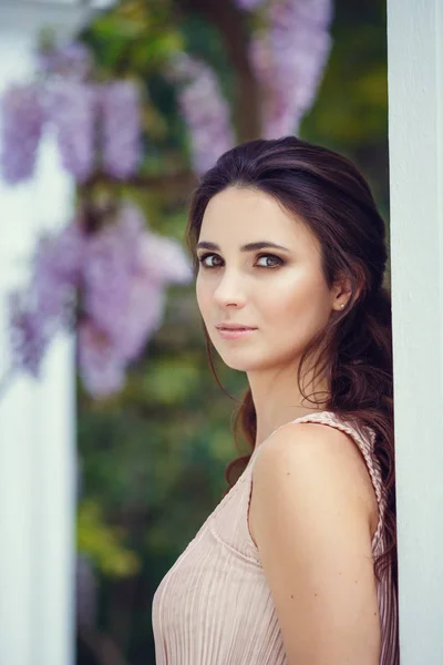 Photo de mode en plein air de magnifique femme aux cheveux foncés dans une élégante robe rose posant au parc d'été — Photo