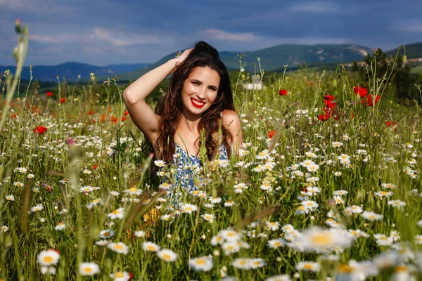 Beautiful woman in a field with flowers — Stock Photo, Image