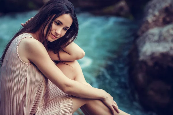 Řeka čarodějka, sedící na kameni v řece. Růžové šaty, Skvělé snímky. Módní tónování. Creative barva. — Stock fotografie