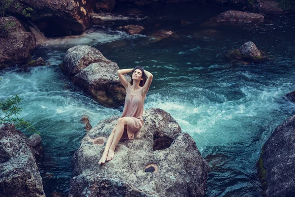 Strega del fiume, seduta su una roccia nel fiume. Abito rosa, un'immagine favolosa.Tonificante alla moda. Colore creativo . — Foto Stock