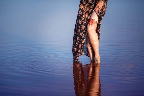 Donna sexy sulla sabbia accanto a un lago con acqua rosa — Foto Stock