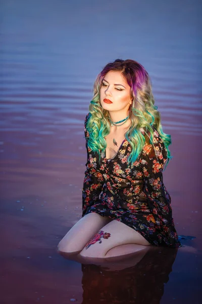 Сексуальна жінка на піску біля озера з рожевою водою — стокове фото