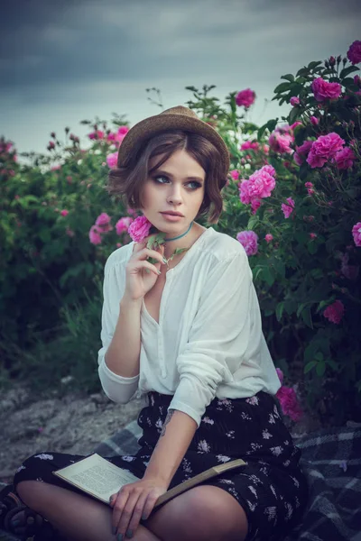 Série de flores. Campo rosa. Crimeia, a aldeia de Turgenyevka. Uma menina do campo gosta do pôr-do-sol, do vinho e da leitura de livros no perfumado jardim de rosas. O conceito de perfume — Fotografia de Stock