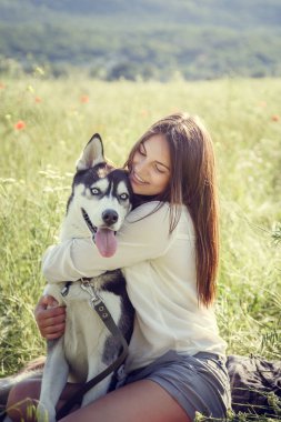Genç güzel kız bir köpekle oynamayı. Köpekle park üzerinde oynamak. Yakın çekim portre. Siberian dış yapraklar.