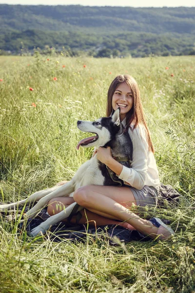 Ung vacker flicka som leker med en hund. Leker med hunden på parken. Närbild porträtt. Siberian husky. — Stockfoto