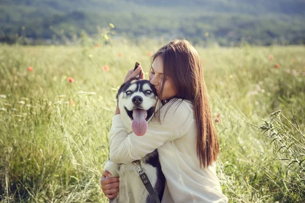 Jeune belle fille jouant avec un chien. Jouer avec le chien sur le parc. Portrait en gros plan. husky sibérien . — Photo