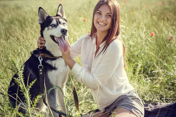 Mooi meisje met een hond spelen. Spelen met de hond op het park. Close-up portret. Siberische husky. — Stockfoto