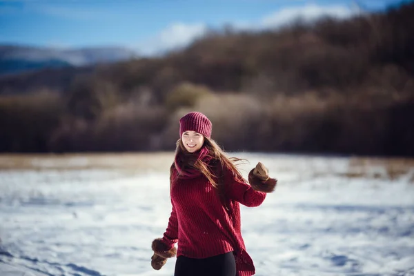 Девушка в тёплой зимней одежде и шляпе, дующей снегом в зимнем лесу . — стоковое фото