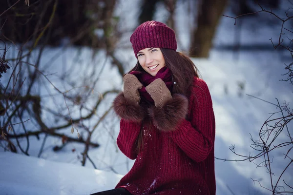 Una chica que usa ropa cálida de invierno y sombrero que sopla nieve en el bosque de invierno . —  Fotos de Stock