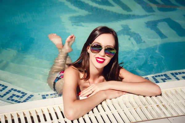 Hermoso cabello largo modelo femenino posando junto a la piscina, retrato al aire libre — Foto de Stock