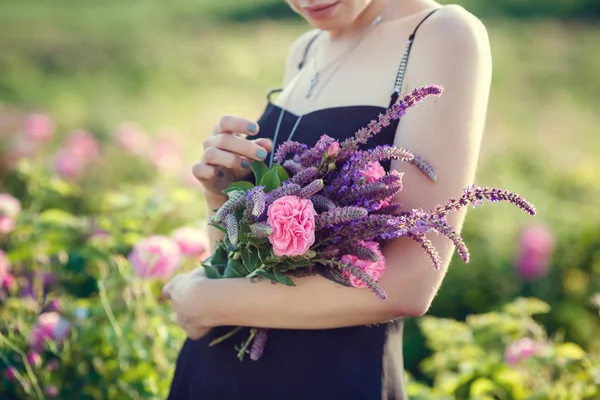 Belle jeune femme dans une roseraie fleurie — Photo