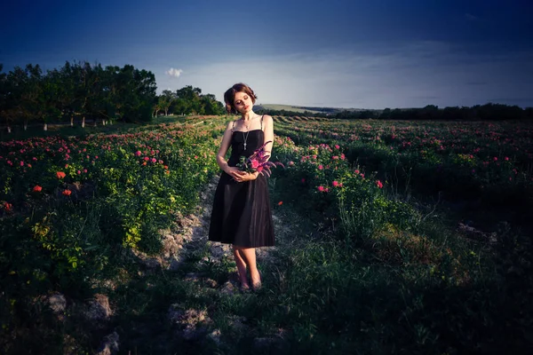 咲くバラ園の美しい若い女性 — ストック写真